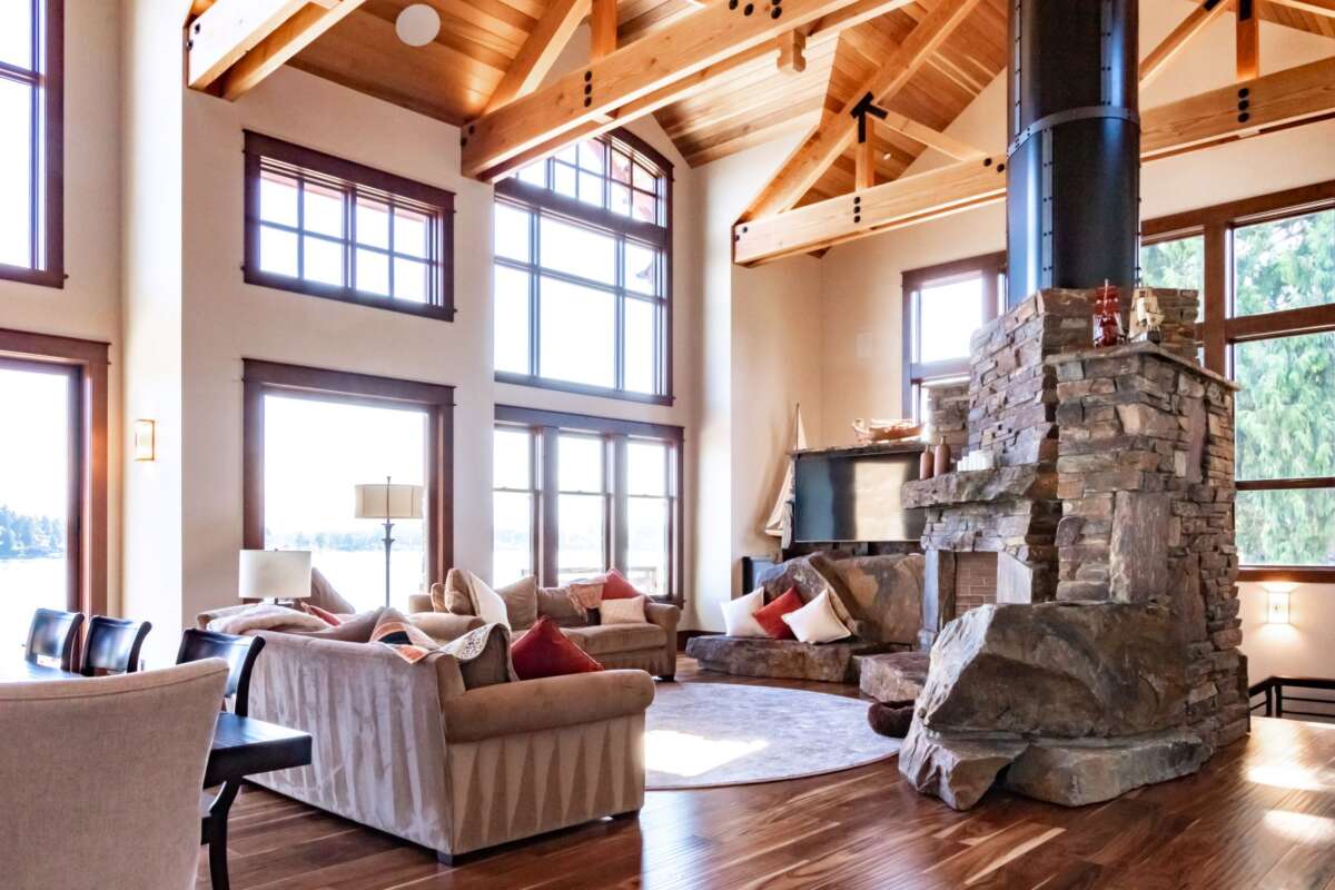large open living room with vast windows wood ceiling and fireplace