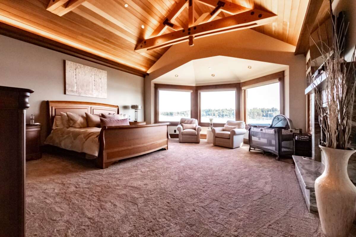 master bedroom with carpet and wood stained ceiling