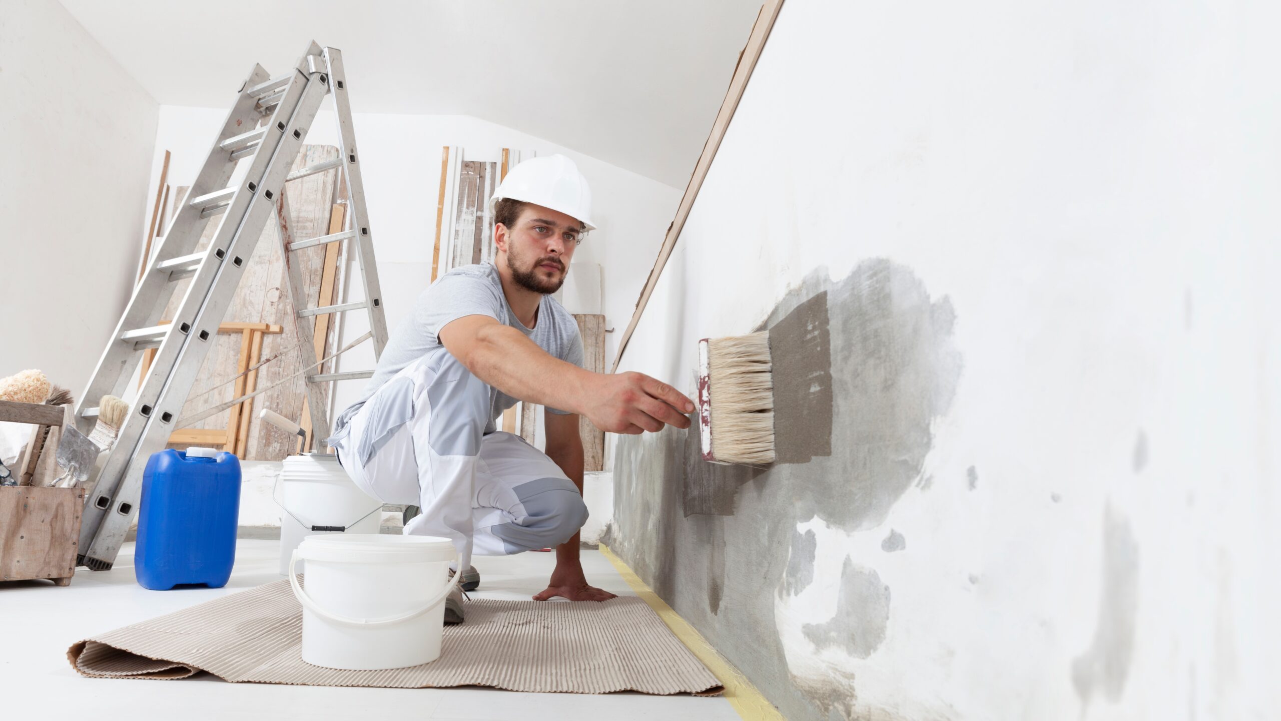 Commercial painting in safety gear painting wall in commercial building