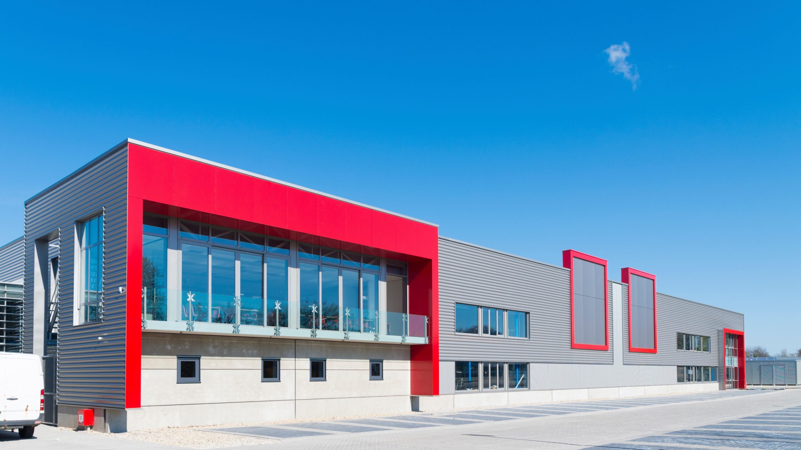 Corporate office building with grey siding and red-trimmed windows
