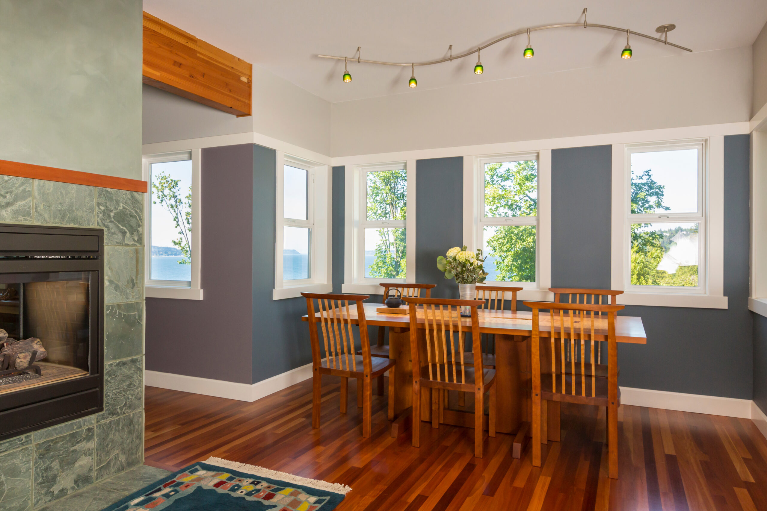 Newly-painted dining room in denim blue with wood table and chairs