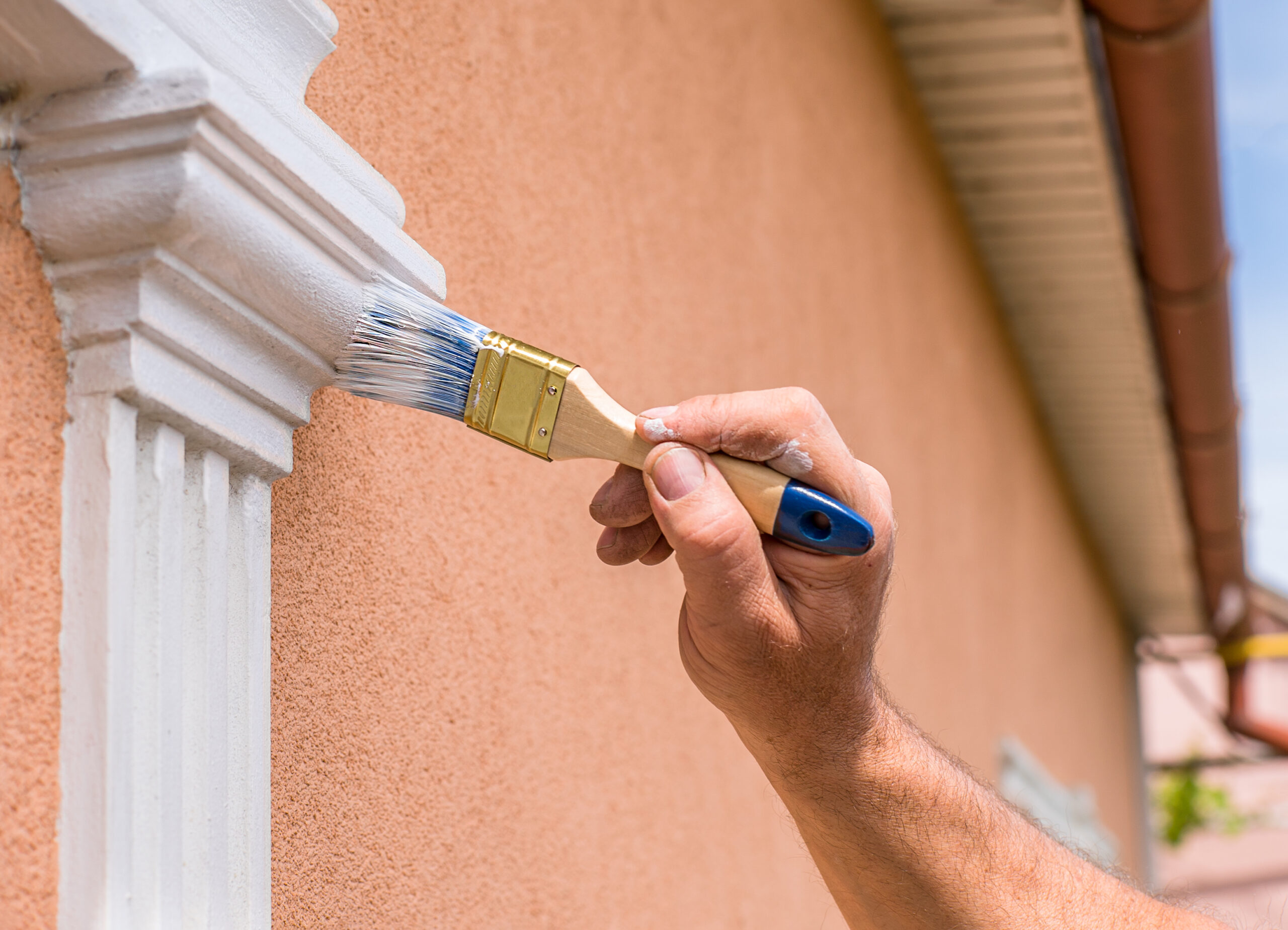 Hand painting exterior trim in white on tan house